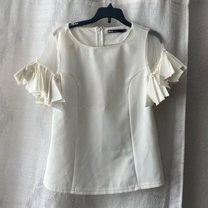 A beautiful classy cream blouse with a lovely ruffled sleeve.